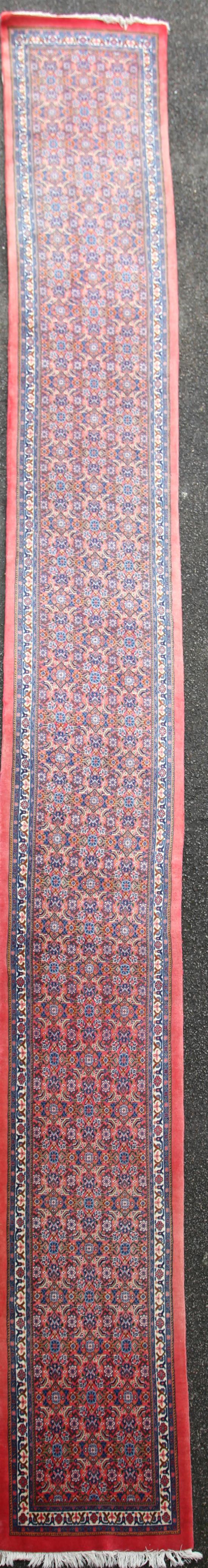 A Persian runner, 20ft 10in. x 2ft 6in.